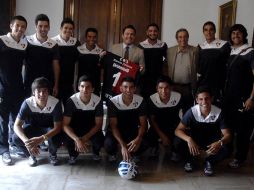 Aristóteles Sandoval (centro) muestra la playera que los jugadores del Atlas le regalaron esta tarde. ESPECIAL /