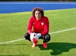 Con pantalón negro y jersey rojo, el guardameta mexicano atiende a las indicaciones de su entrenador. Foto: @MalagaCF. ESPECIAL /