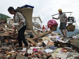 Dos supervivientes del terremoto en Longtoushan recuperan algunas de sus posesiones. EFE /
