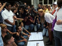 La esposa de Leopoldo López, Lilian Tintori, habla con jóvenes a las afueras de la Corte venezolana. AFP /