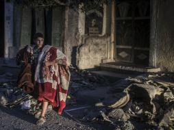 Un joven palestino carga unas cobijas mientras abandona su casa. EFE /