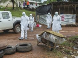 Enfermeros se aproximan al lugar donde hay un cuerpo de una víctima del ébola. EFE /