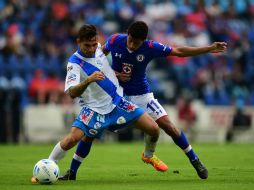 Acción de juego entre Flavio Santos de Puebla y Joao Rojas de Cruz Azul. AFP /