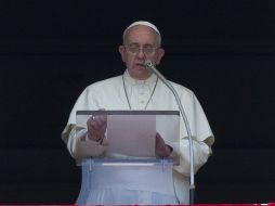 Desde la ventana de su estudio, el Papa Francisco reza el Angelus y lee el mensaje. AP /