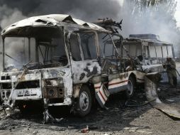 Varios autobuses atrapados entre dos fuegos siguen ardiendo esta mañana del domingo. AP /
