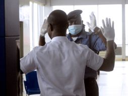 Personal de seguridad del aeropuerto Murtala Muhammed de Nigeria, realiza inspección a pasajeros. AFP /