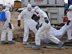 Enfermeros cargan el cuerpo de una de las personas que falleció a causa del ébola. AP /