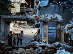 Una familia palestina mira los escombros de casas destruidas por los bombardeos israelíes. AFP /