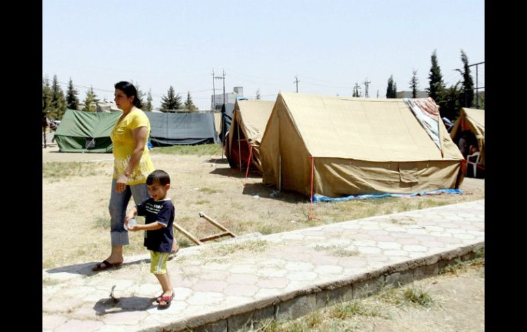 Una mujer y un niño cristianos e iraquíes caminan en un nuevo campo de refugiados forzados a huir de sus hogares. EFE /