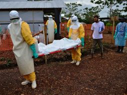 Elementos de MSF cargan el cuerpo de una víctima del ébola. AFP /
