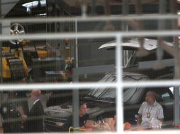 Investigadores examinan el carro donde fueron encontrados dos jóvenes fallecidos. AP /