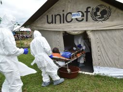 Enfermeros llevan a un hombre en una camilla en una sala de aislamiento durante una operación de simulación. AFP /