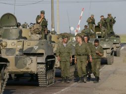 Soldados descansan junto a vehículos armados rusos a 30 km de la frontera de Rusia con Ucrania mientras transportan ayuda humanitaria. EFE /