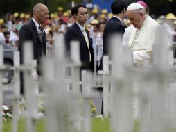 El Papa inclina la cabeza para orar frente al monumento, ''un jardín moteado de cruces blancas de madera''. AP /