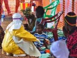 Un trabajador de Médicos Sin Fronteras alimenta a un menor víctima del ébola en Kailahun. AFP /