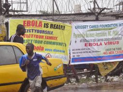 Autoridades muestran varios carteles sobre las señales de advertencia del ébola en diversas ciudadades de Liberia. AP /