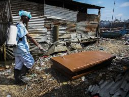 Un enfermero liberiano desinfecta colchones sacados de una escuela primaria en Liberia. EFE /