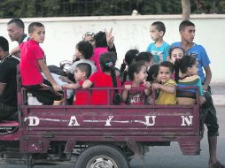 Desplazados. Palestinos huyen con sus pertenencias del barrio Shejaiya, de Gaza, para buscar refugio en una escuela de la ONU. AFP /
