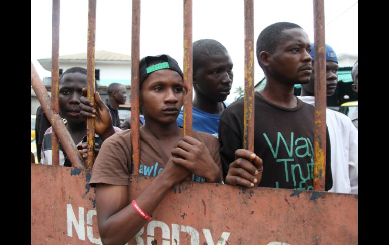 Residentes de Guinea esperan que les sean entregados alimentos como parte de un plan de cuarentena. ARCHIVO /