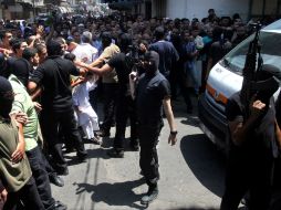 Militantes enmascarados armados palestinos hacen retroceder a una multitud de fieles, antes de la ejecución de 18 hombres. AFP /