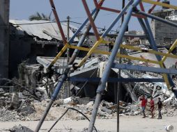 Niños palestinos caminan entre los restos de edificios en el norte de la Franja de Gaza. AFP /
