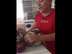 La mujer es fuertemente reprimida por llevarse, sin permiso, un chile en nogada. ESPECIAL /