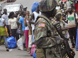 En Libera, soldados revisan a la población para determinar si están contagiados. AP /