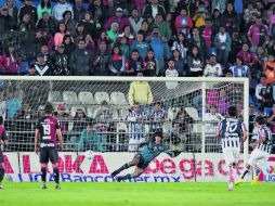 Matías Alustiza engaña al portero rojinegro Federico Vilar para clavar el último gol de los Tuzos.  /