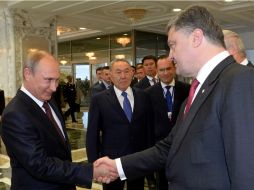 Los presidentes de Rusia y Ucrania se dan un apretón de manos para las cámaras. AFP /