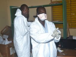 Enfermeros se retiran su traje de protección tras terminar su trabajo en un hospital de África. AFP /