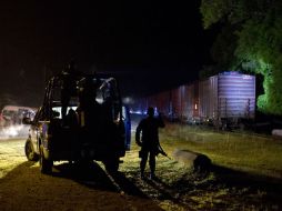 Policías revisan los vagones del tren de 'La Bestia' en busca de migrantes, en San Ramón, Chiapas. AP /