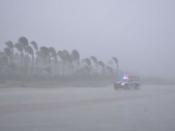 Un vehículo transita por una playa en medio de lluvia y fuertes vientos debido a la entrada de 'Odile' a Los Cabos. EFE  C. Robalo.  /