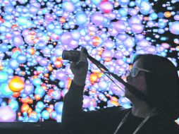 Atracción. Una asistente al International Consumer Electronics Show graba un video de una pantalla de pared LG Ultra HD. AP /