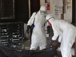 Médicos portan su traje de seguridad para remover el cuerpo de una víctima de ébola en Liberia. AP  A. Dulleh  /