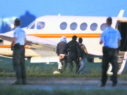 Un presunto yihadista es escoltado esposado por la Policía francesa hacia un avión, luego de ser detenido tras su regreso de Turquía. EFE /
