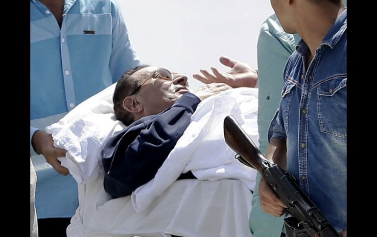 Médicos y militares egipcios acompañan a Hosni Mubarak, luego de escuchar que su veredicto es pospuesto hasta Noviembre. AP / H. Ammar