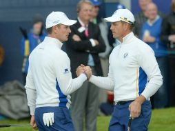 Justin Rose (izq.) felicita a su  compañero Henrik Stenson al finalizar su partipación matutina. EFE /  F. Arrizabalaga