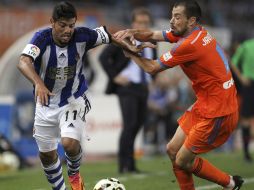 El delantero mexicano recibe una tarjeta amarilla por empujar al argentino Otamendi. EFE / J. Herrera