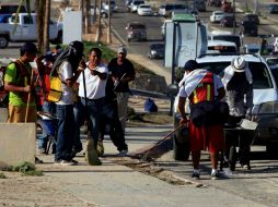 Estudiantes participan en el programa de empleo temporal para remover los escombros que dejó el huracán 'Odile'. SUN / ARCHIVO