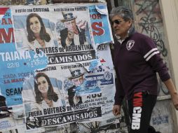 En Buenos Aires, un hombre pasa junto a un cartel con un mensaje en contra los fondos buitres. EFE / D. Fernández