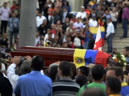 Los restos del chavista Robert Serra llega a la Asamblea General venezolana, cubierto con la bandera nacional. AFP / F. Parra