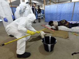 Trabajadores de la salud muestran a personal de la OMS cómo se atiende a un paciente infectado del virus. AFP / P. Guyot