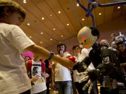 El androide iCub interactúa con un niño en la European Maker Faire, en Roma. AP / A. Tarantino