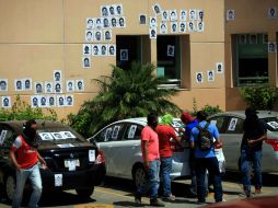 Los alumnos pegan fotocopias con las fotografías de sus 43 compañeros en las paredes de la Fiscalía. SUN / J. Serratos
