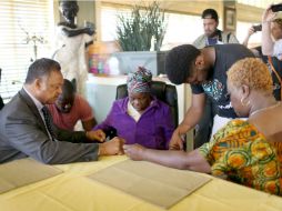 El reverendo Jesse Jackson ora con Nowai Korkoyah (c), madre del paciente con ébola, por la salud de su hijo. AFP / J. Raedle