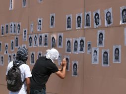 Protestantes colocan en el Congreso de Guerrero imágenes de los 43 normalistas desaparecidos. EFE / J. De la Cruz