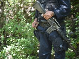 Un oficial de policía custodia las inmediaciones de las fosas clandestinas donde se encontraron los cuerpos. AFP / Y. Cortez