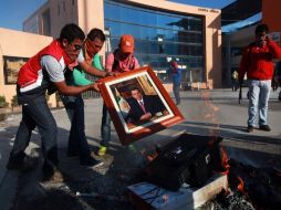 Un grupo de estudiantes quema una fotografía oficial del gobernador Angel Aguirre durante los disturbios. AP / F. Márquez