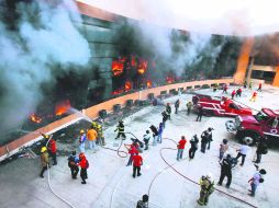 En llamas. Los estudiantes de Ayotzinapa rompieron los vidrios y lanzaron artefactos explosivos. AP /  F. Márquez