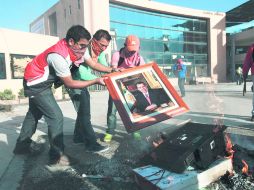 Los normalistas quemaron diversos aparatos sustraidos en el Congreso, incluida una fotografía oficial del gobernador Ángel Aguirre. AP /